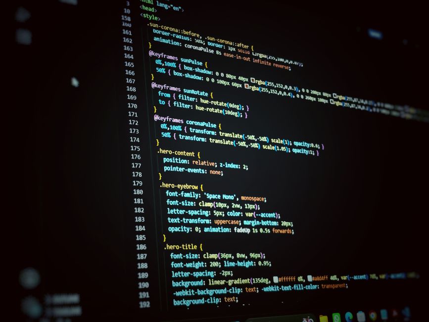 A computer screen displaying a dark-themed code editor with visible HTML and CSS code. The code includes tags such as <!DOCTYPE html>, <html>, <head>, <meta>, <title>, and <link>, with some text blurr